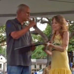 Sen. Mike Gabbard presents Joy with a certificate on stage at VegFest