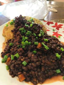 garnished lentils over scoop of brown rice