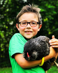 VeganEvan smiling and holding a chicken