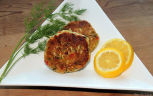 zucchini oatmeal patties on plate with orange and dill garnish