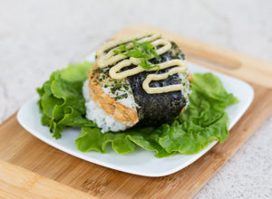 Sushi Burger plated with lettuce and sauce
